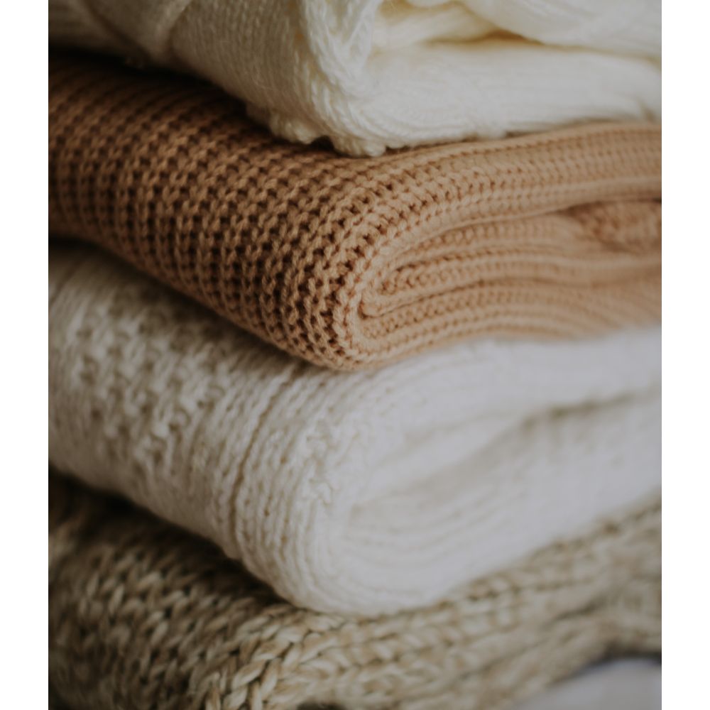 Folded blankets in beige, brown and cream
