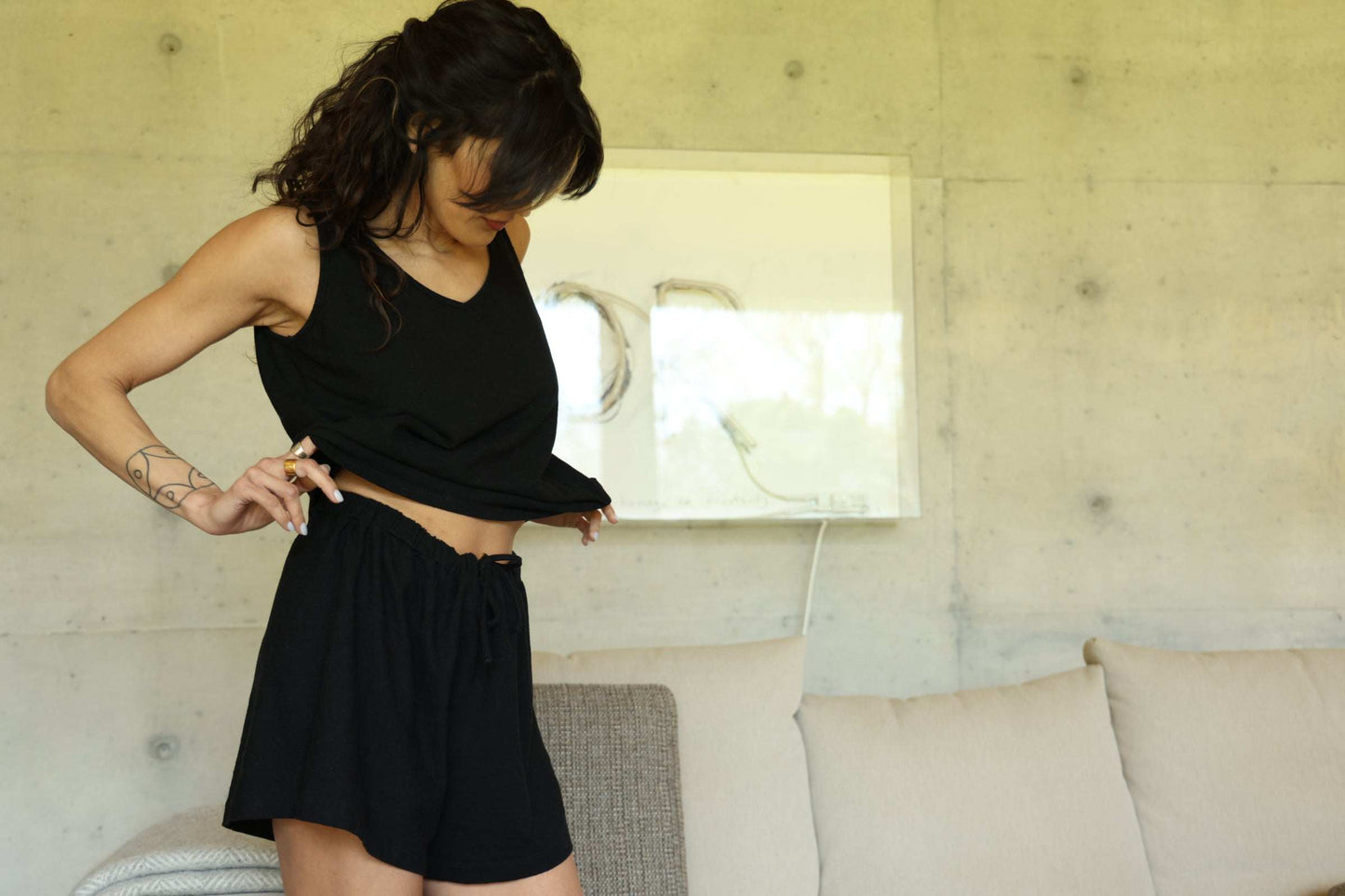 Woman wearing black moisture-wicking tank top and shorts for night sweats.