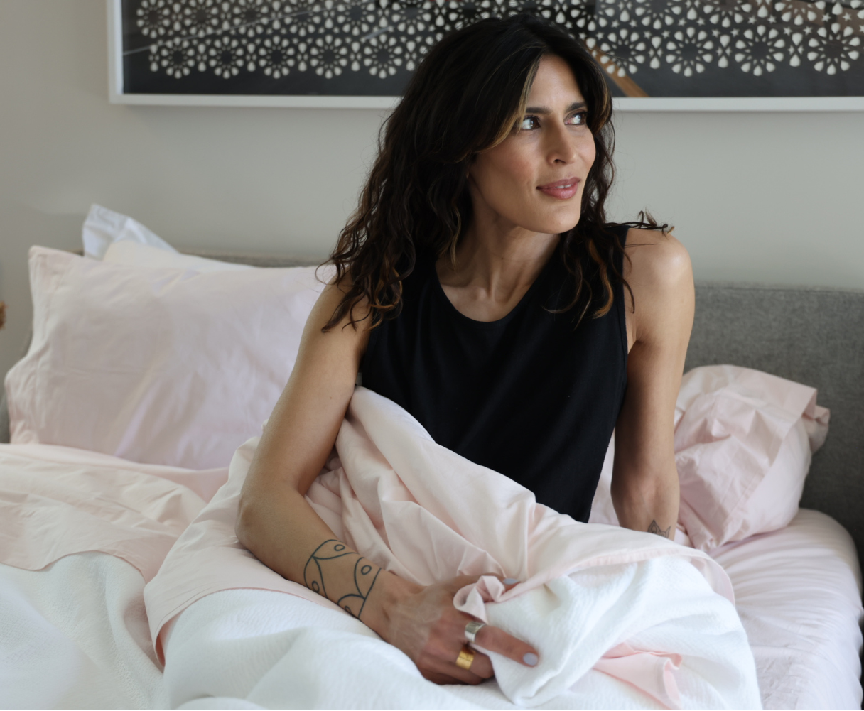 Woman wearing black hemp/cotton nightgown, sitting in bed.