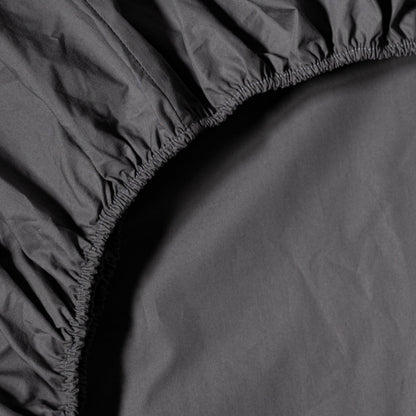 Close-up of a black fitted organic percale sheet with elasticized top corner