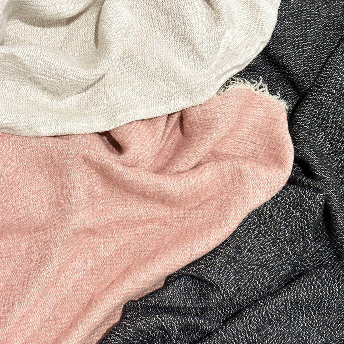 Close-up oflinen throw swatches in beige, pink, and gray.